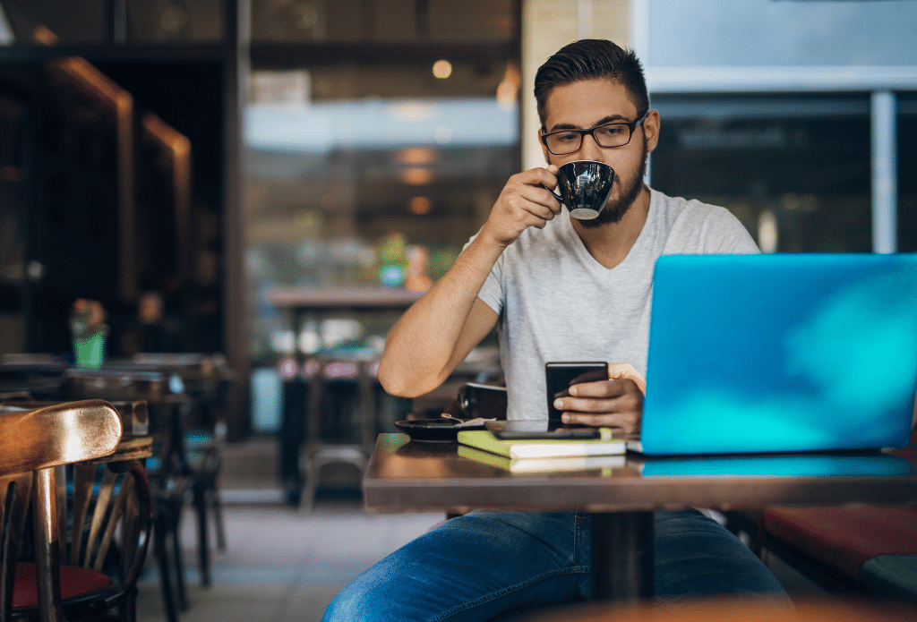 Mann mit Laptop im Café